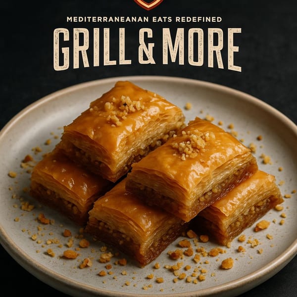 Four pieces of golden baklava with chopped nuts on a light grey plate, with "Grill & More" text.